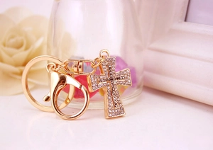 Close-up of golden cross keychain with shimmering rhinestones and secure lobster clasp
