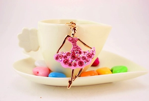Close-up of pink crystal ballet girl pendant with rose gold finish on a heart dish