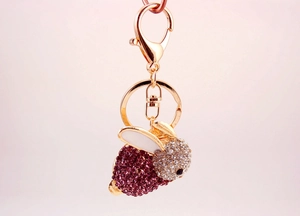 Détails d'un porte-clés lapin en or rose orné de strass roses et transparents brillants