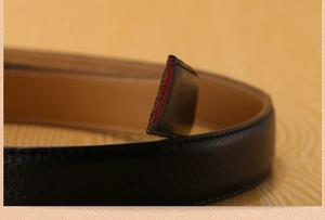 Macro shot of black leather belt strap with litchi texture and red edge detail