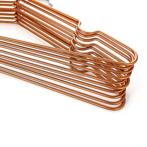 Close-up of rose gold metal hangers with non-slip shoulder grooves and smooth finish