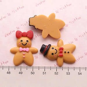 Macro detail of 3cm Christmas gingerbread man resin charms with a measurement scale