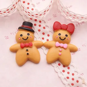 Flat lay of resin gingerbread man charms with cute hats and bows for DIY craft projects