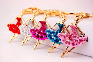 Detail of ballet dancer keychains featuring crystal encrusted skirts in five vibrant colors