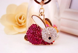 Gros plan du porte-clés lapin en strass rose avec anneau et chaîne en métal doré brillant