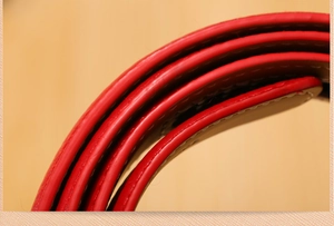Close-up of red cowhide leather belt strap showing fine texture and edge stitching