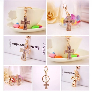 Detail of cross keychain with clear and black rhinestones on gold-toned metal base