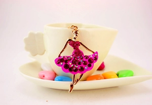 Macro view of ballet dancer keychain with sparkling rose pink rhinestones on gold base