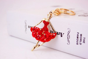 Close-up of ballet dancer keychain with vibrant red rhinestones and gold alloy finish