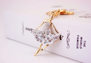 Detailed close-up of sparkling rhinestone ballet dancer keychain on a gold alloy frame