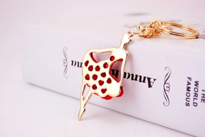 Detailed view of ballet girl metal keychain with red crystals on golden dress