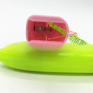 Detail view of the green and pink electric milk frother with internal battery compartment