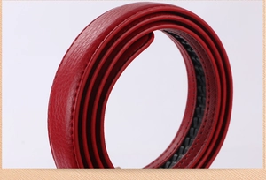Detailed macro view of a red leather belt strap showing the internal black ratcheting track