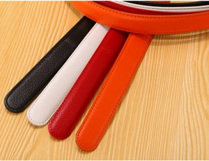 Close-up of colorful leather belts without buckles in orange, black, white, and red