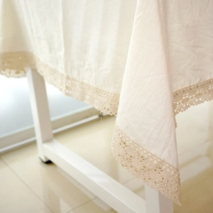 Close-up of beige cotton linen tablecloth featuring intricate lace edge detailing
