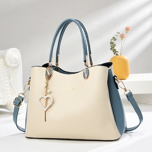 Sac à main élégant en cuir blanc et bleu avec anneaux dorés et charm en perle
