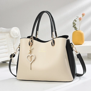Sac à main chic blanc et noir avec logo doré et pendentif cœur sur fond minimal
