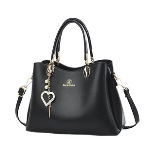 Sac à main noir chic avec bordure ondulée et pendentif cœur doré avec perle de luxe