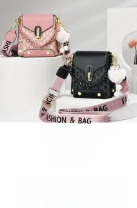 Detail of pink and black leather bags with M-pattern, gold locks and furry charms