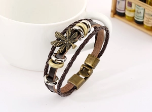Dettaglio del bracciale multistrato in pelle intrecciata con ciondolo a foglia d'acero