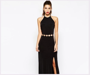 Detail of golden metal circle waist chain on a black dress highlighting high-end fashion