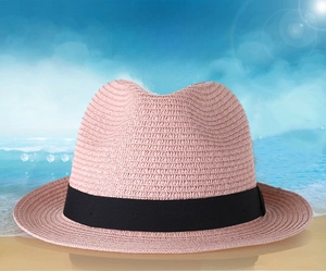 Détail d'un chapeau fedora en paille tressée rose avec ruban noir pour protection solaire