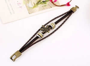 Dettaglio del bracciale in pelle intrecciata con ciondolo a foglia d'acero e fibbia