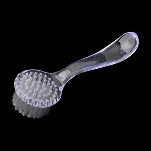 Détail du manche ergonomique en S et des poils blancs denses de la brosse à ongles