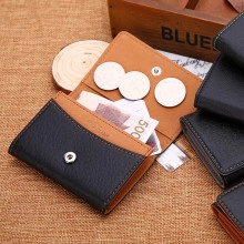 Detail view of leather coin purse with three circular slots and a snap button closure