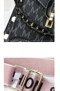 Detail of black monogram handbag with woven handle and pink wide fabric strap with gold buckle