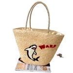 Detail of handwoven straw tote featuring cartoon shark embroidery and red WARP text