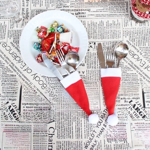 Gros plan sur des porte-couverts en forme de mini bonnets de Noël rouges et blancs