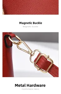 Detail of red lychee grain leather with gold stamped logo and metallic swivel hooks