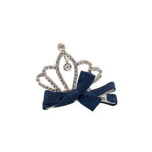 Elegant silver crystal crown hair clip with a navy blue ribbon bow on white background