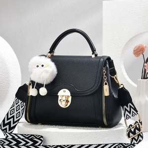 Minimalistische zwarte leren crossbodytas met golfpatroon riem en pluche hanger