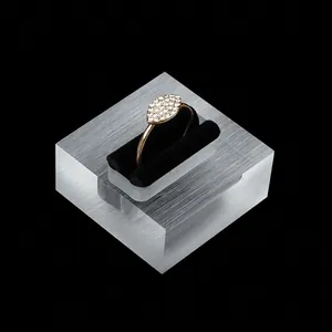 Golden marquise-shaped ring with pavé crystals on a transparent acrylic display stand