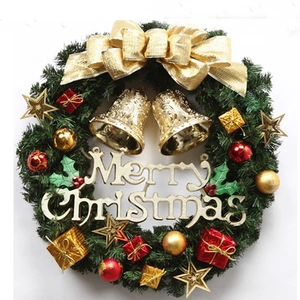 Detail of Christmas wreath with golden bells, red ornaments, and Merry Christmas sign
