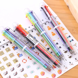 Detail of four transparent 6-color retractable ballpoint pens on a spiral notebook