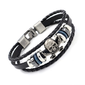 Close-up of a multi-layer punk leather bracelet with a silver skull and crossbones charm