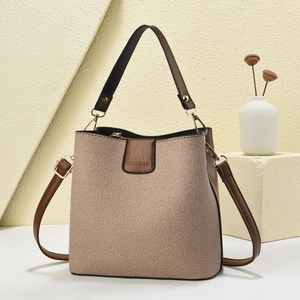 Fashion bucket bag with brown leather and woven canvas texture, including a shoulder strap