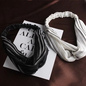 Detail of cross-knot headband with abstract geometric stripes on textured linen fabric
