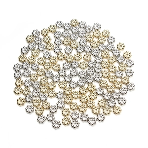 Close-up of gold and silver flower shaped spacer beads for DIY jewelry making and crafts