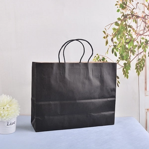 Detail of matte black paper gift bag with matching twisted paper rope handles