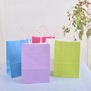 Close-up of assorted colorful kraft paper gift bags with sturdy white handles