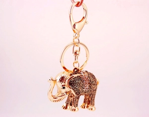 Macro shot of golden elephant keychain with embossed patterns and sparkling rhinestones