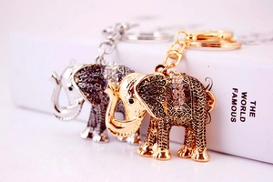 Detail of vintage metal elephant keychains in gold and silver with clear rhinestones