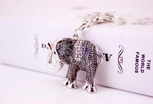 Close-up of silver elephant keychain with sparkling rhinestones on white gift box