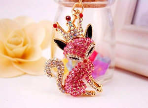 Macro shot of a golden fox keychain with pink rhinestones and a sparkling crown detail