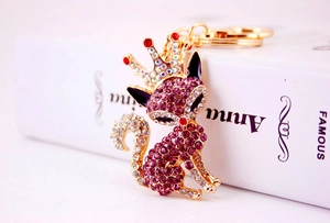 Close-up of golden fox keychain with purple rhinestones and black enamel ears
