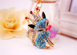 Detailed close-up of a golden fox keychain featuring blue rhinestones and a red crown